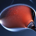 Photographie d'un verre de vin rouge, vu de dessous.