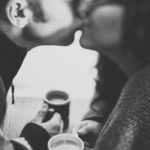 Photo d'un couple qui s'embrasse autour d'un café.