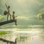 Photographie de deux jeunes enfants qui pêchent dans un lac en Asie.