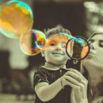 Photographie d'une mère et son fils faisant des bulles de savon.