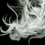Photographie en noir et blanc, d'une femme au cheveux longs qui s'emmêlent