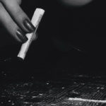 Photographie en noir et blanc d'une jeune femme qui prépare un rail de cocaïne